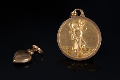 médaille plaquée or ornée d'un pendentif en forme de cœur sur un fond noir