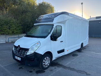 une camionnette blanche garée sur un parking avec des arbres en arrière-plan