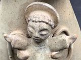 a statue of an angel holding a bird in its hands