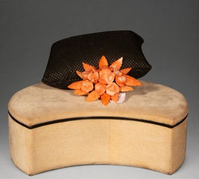 un chapeau posé sur une boîte ornée d'une fleur