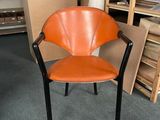 an orange chair that is sitting in the middle of a room