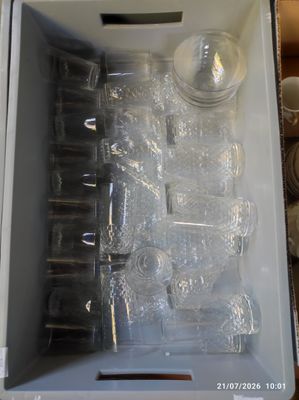 une boîte blanche remplie de gobelets et de verres en plastique vides