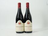 deux bouteilles de vin rouge posées l'une à côté de l'autre sur une surface blanche