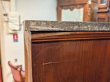 a wooden cabinet with a marble top in a room