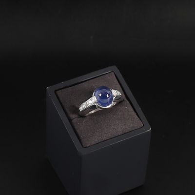 an image of a ring in a box with a blue stone