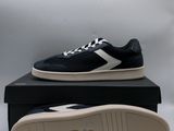 a pair of black and white sneakers sitting on top of a box