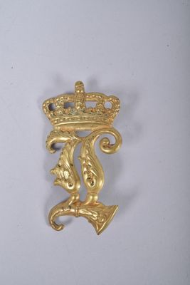 un gros plan d'une broche en or ornée d'une couronne
