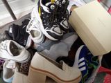 many pairs of shoes and a shoe box in a basket