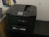 a printer sitting on top of a desk next to a phone