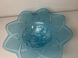 a blue glass bowl with a flower design on it