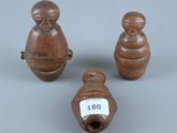 trois petites figurines en bois représentant des singes et une clochette