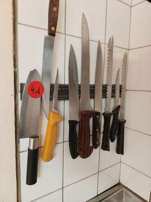 de nombreux couteaux accrochés au mur de la cuisine