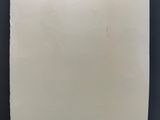 une feuille de papier vierge accrochée à un mur noir