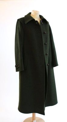 un manteau vert sur un mannequin, sur fond blanc