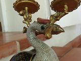 a bird that is sitting on top of a candle holder