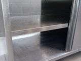 a stainless steel counter in a kitchen with a glass door