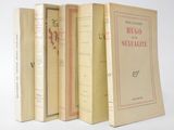 several books are lined up in a row on a white surface