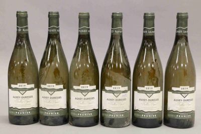 six bouteilles de vin sont alignées sur une table