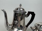 a silver tea pot and a silver tea pot on a table