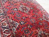 an old persian rug is on the floor next to a pile of boxes