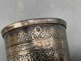 a silver cup that is sitting on a table