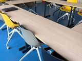 des tables et des chaises dans une pièce avec une moquette bleue et des chaises jaunes