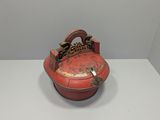 an old red box with a chain hanging from it on a white surface