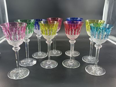 several different colored wine glasses are lined up on a table