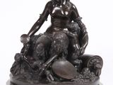 statue en bronze représentant une femme assise sur un rocher avec un chien