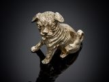 une figurine en or représentant un chien assis sur une surface noire