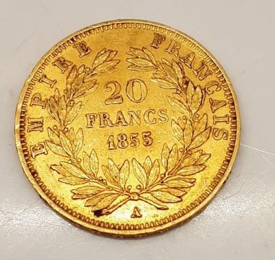 gros plan d'une pièce d'or sur une surface blanche