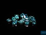 un gros plan sur un bouquet de diamants bleus posés sur une surface noire