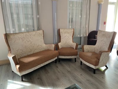 trois fauteuils et un canapé dans un salon