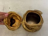 a person holding a gold vase next to a gold vase