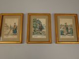 three framed pictures of people on a wall in a room