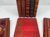 three red books sitting next to each other on a white surface