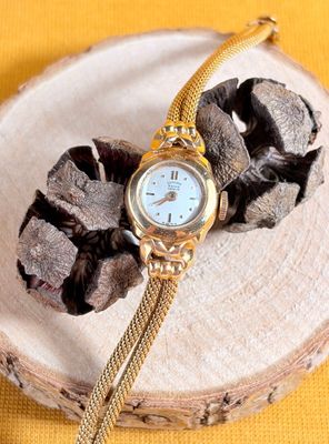 a watch sitting on top of a piece of wood