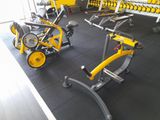 une salle de sport équipée d'une rangée de vélos d'appartement et d'haltères