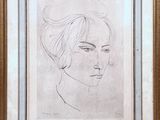 On voit le dessin du visage d'une femme dans un cadre doré