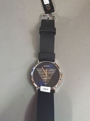 une montre-bracelet munie d'une étiquette, accrochée à un mur
