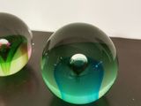 two glass balls sitting next to each other on a table