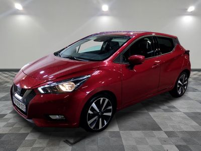 une Nissan Micna rouge garée sur un sol à damier