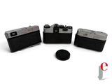 three cameras sitting next to each other on a white surface