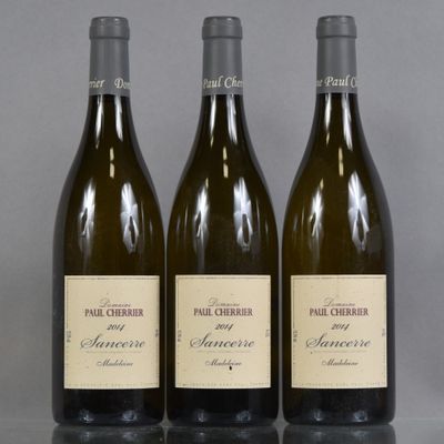 trois bouteilles de vin posées sur une table l'une à côté de l'autre