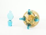 a small toy that is standing next to a glass ball