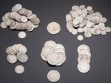 some coins are scattered on a black surface with a gray background