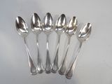 six silver spoons are lined up on a white surface