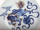 a blue and white plate with a picture of a dragon on it