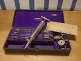 a silver razor in a purple case on a wooden table