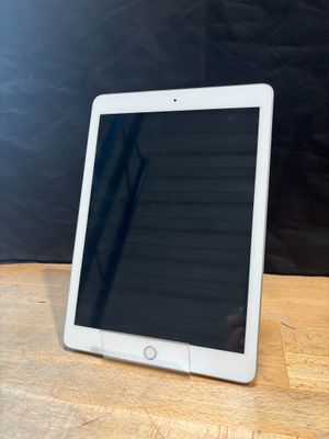 an ipad is sitting on a wooden table with a black background